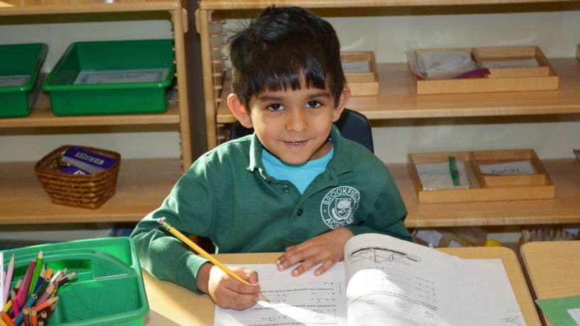 Young child writing in journal